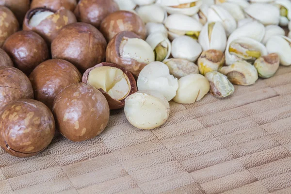 Macadamia en pistache noten op houten tafel. — Stockfoto