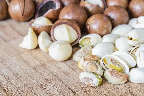 Macadamia en pistache noten op houten tafel. — Stockfoto