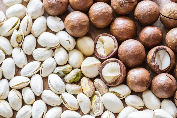 Macadamia en pistache noten op houten tafel. — Stockfoto