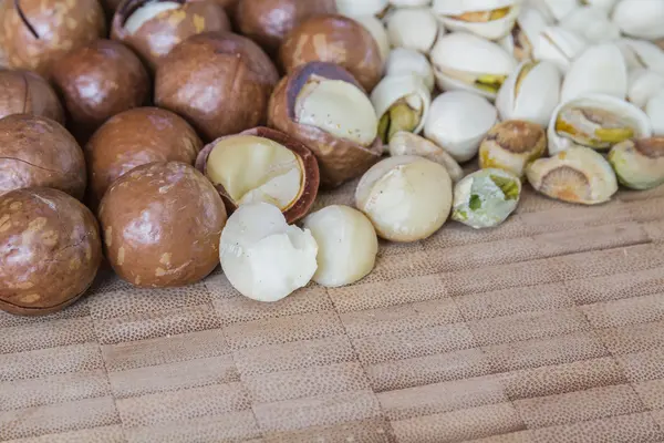 Macadamia en pistache noten op houten tafel. — Stockfoto