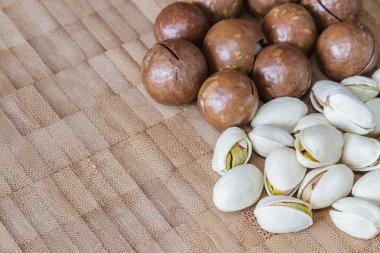 Macadamia ve fıstık fındık ahşap masa üzerinde.