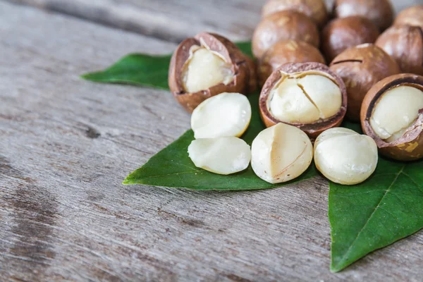 Macadamia op houten tafel. — Stockfoto