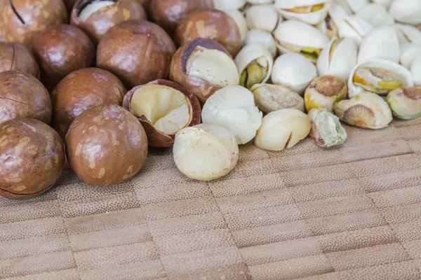 Macadamia en pistache noten op houten tafel. — Stockfoto