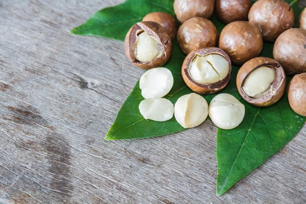 Macadamia op houten tafel. — Stockfoto