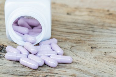 Ahşap arka plan üzerinde ilaç kapsül