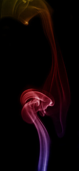 Smoke color yellow, red and blue isolated on black background.