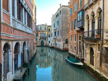 Venedik 'te bir kanal caddesinde küçük bir tekne. Güzel renkli evler, İtalya. Mavi gökyüzü
