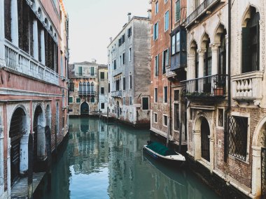 Venedik 'te bir kanal caddesinde küçük bir tekne. Güzel renkli evler, İtalya. Mavi gökyüzü