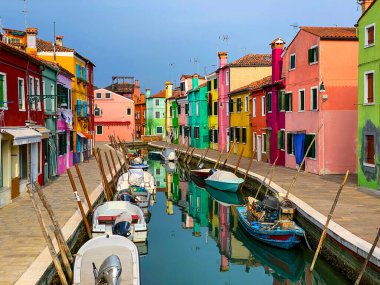 Burano Adası, Venedik 'teki kanal evlerinde tekneler ve renkli evler, arka planda tanınmayan insanlar..