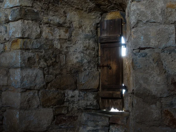 Темна кімната з кам'яними стінами і вікном — стокове фото