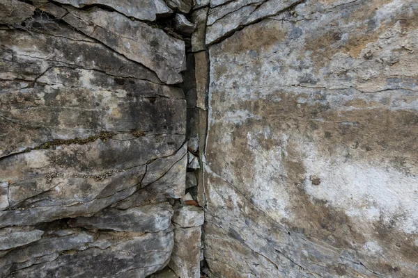 Muro di pietra di roccia con crepe — Foto Stock