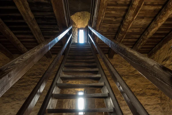 Dark room with stone walls window and wooden staircase — Stock Photo, Image