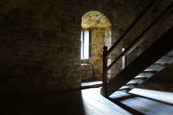 Taş duvarlar pencere ve Ahşap merdiven karanlık oda — Stok fotoğraf
