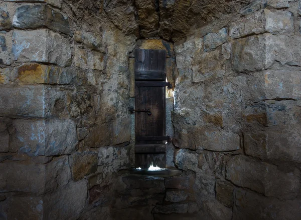 Habitación oscura con paredes de piedra y ventana . — Foto de Stock