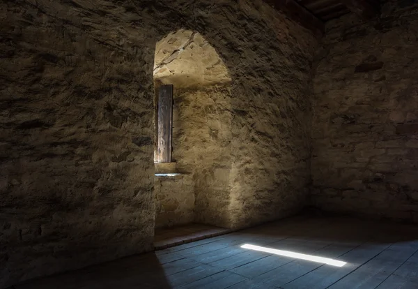 Chambre sombre avec fenêtre murale en pierre et escalier en bois — Photo