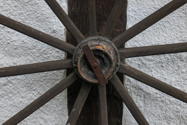 Старое колесо на стене фермерского дома — стоковое фото