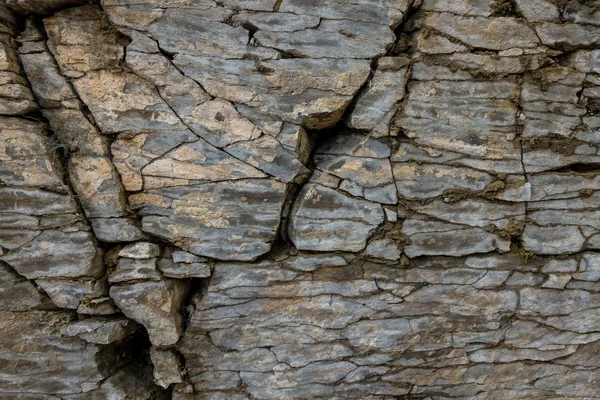 Parede de pedra de rocha com rachaduras — Fotografia de Stock