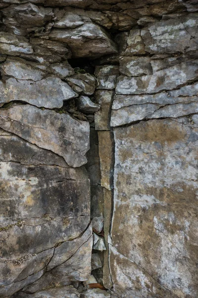 Stenen muur van rots met scheuren — Stockfoto