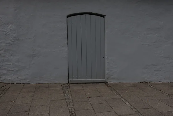 Antigua puerta de madera en la pared de un edificio — Foto de Stock