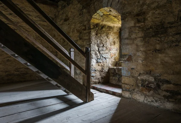 Dunkler Raum mit Steinwänden und Holztreppe — Stockfoto