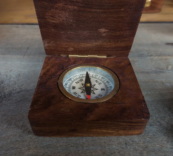 Old compass on a wooden table — Stock Photo, Image