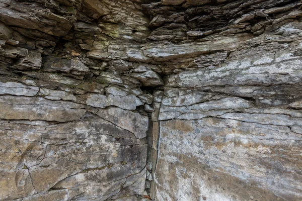 Parede de pedra de rocha com rachaduras — Fotografia de Stock