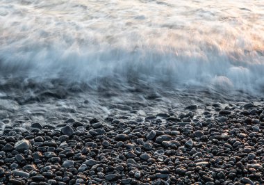 Lanzarote, Kanarya Adaları 'ndaki volkanik kara sahilde sörf. .