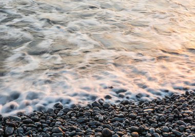 Lanzarote, Kanarya Adaları 'ndaki volkanik kara sahilde sörf. .