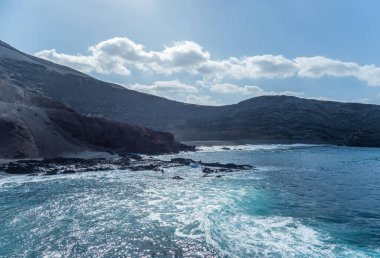 Volkanik siyah plajda sörf El Golfo, ada Lanzarote.