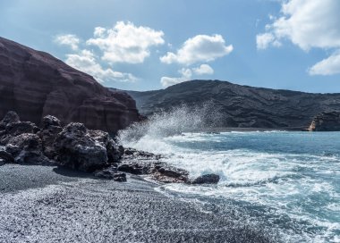 Volkanik siyah plajda sörf El Golfo, ada Lanzarote.