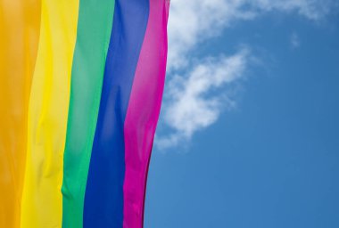 Mavi gökyüzüne karşı gün ışığında gökkuşağı bayrağı