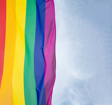 Mavi gökyüzüne karşı gün ışığında gökkuşağı bayrağı