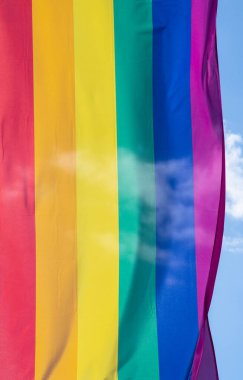 Mavi gökyüzüne karşı gün ışığında gökkuşağı bayrağı