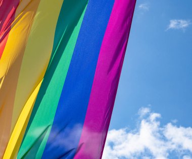 Mavi gökyüzüne karşı gün ışığında gökkuşağı bayrağı