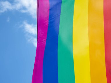 Mavi gökyüzüne karşı gün ışığında gökkuşağı bayrağı