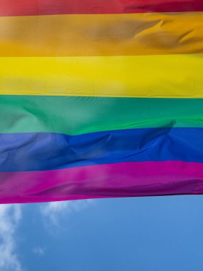 Mavi gökyüzüne karşı gün ışığında gökkuşağı bayrağı