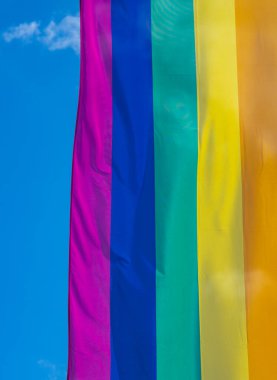 Mavi gökyüzüne karşı gün ışığında gökkuşağı bayrağı