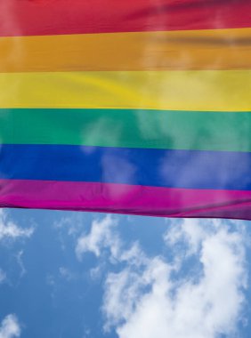 Mavi gökyüzüne karşı gün ışığında gökkuşağı bayrağı