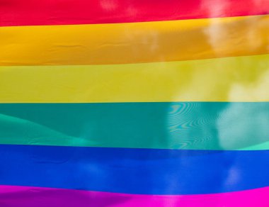 Mavi gökyüzüne karşı gün ışığında gökkuşağı bayrağı