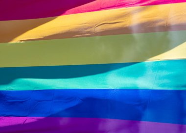 Mavi gökyüzüne karşı gün ışığında gökkuşağı bayrağı