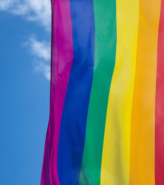 Mavi gökyüzüne karşı gün ışığında gökkuşağı bayrağı