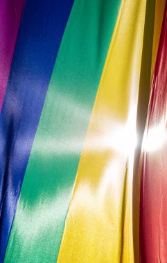 Mavi gökyüzüne karşı gün ışığında gökkuşağı bayrağı