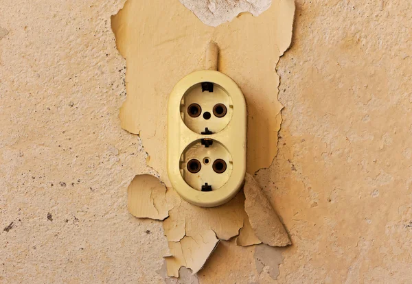 Старая электрическая розетка на дряхлой стене — стоковое фото