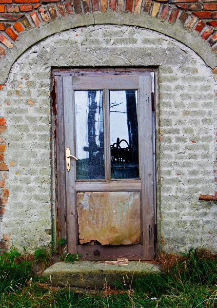 Vecchia porta in legno nella casa di mattoni — Foto Stock