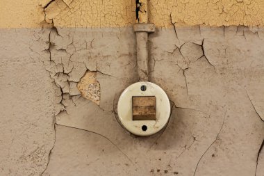 eski elektrik anahtarı ve bir ayağı çukurda duvarda kablo