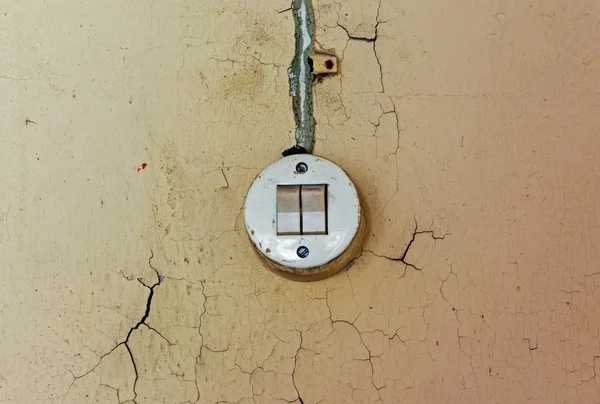 旧电器开关和破旧的墙上的电缆 — 图库照片
