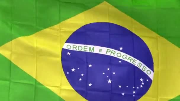 Braziliaanse vlag in de wind in zonlicht — Stockvideo