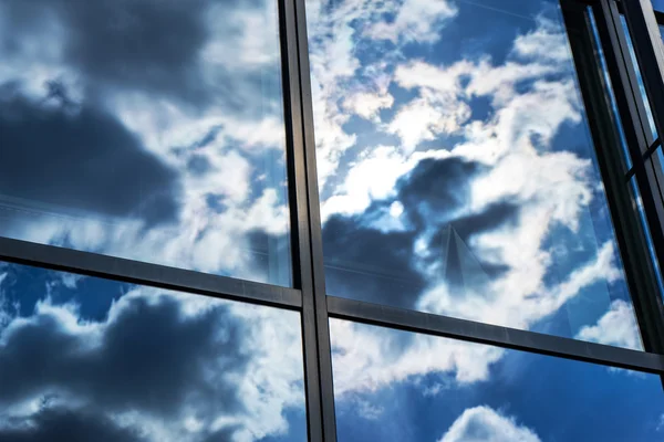 Reflection of the sky and clouds in the windows of  building — Stock Photo, Image