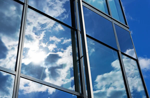 Riflessione del cielo e delle nuvole nelle finestre dell'edificio — Foto Stock