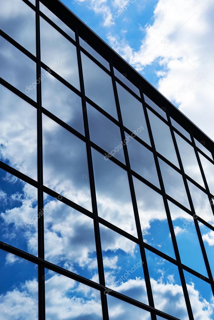 Reflection of the sky and clouds in the windows of  building